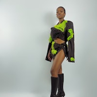 a woman in a black and green outfit posing for a photo
