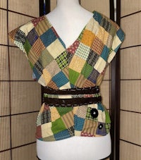 a patchwork top with a belt on a mannequin