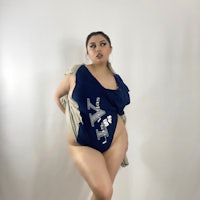 a woman in a blue bodysuit posing for a photo