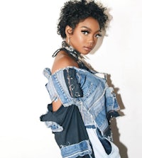 a black woman in a denim jacket posing for a photo