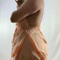 a woman in a peach dress posing for a photo