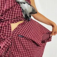 a woman wearing a red and white checkered skirt